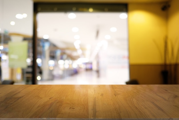 Photo empty dark wooden table in front of abstract blurred background of coffee shop . can be used for display or montage your products.mock up for display of product.