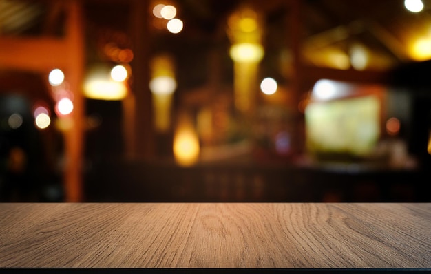 Photo empty dark wooden table in front of abstract blurred bokeh background of restaurant can be used for display or montage your productsmock up for space