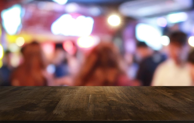 레스토랑의 추상적으로 흐릿한 보케 배경 앞에 있는 빈 어두운 나무 테이블은 공간을 위해 제품을 표시하거나 몽타주하는 데 사용할 수 있습니다.