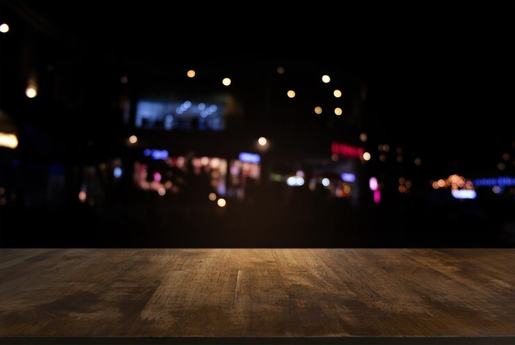 Photo empty dark wooden table in front of abstract blurred bokeh background of restaurant