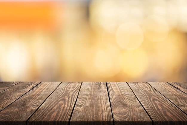 Empty dark wooden table in front of abstract blurred bokeh background of restaurant .