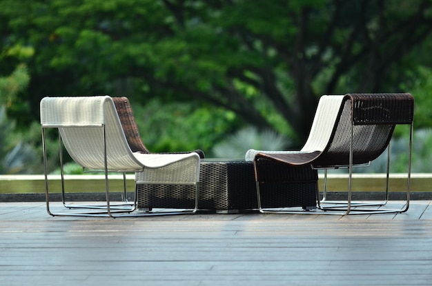 Photo empty deck chairs and table on boardwalk at park