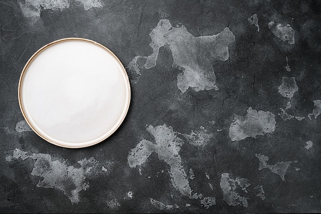 Empty dinner plate set with copy space for text or food with copy space for text or food, top view flat lay, on black dark stone table background