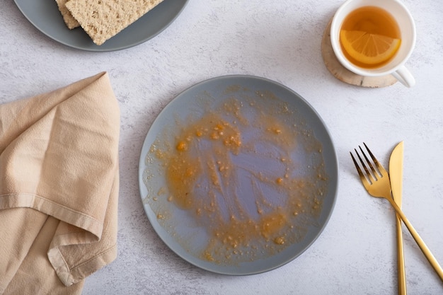 Empty dirty plate and fork with knife with food eaten top view