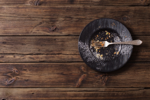 Empty dirty plate on old wooden wall