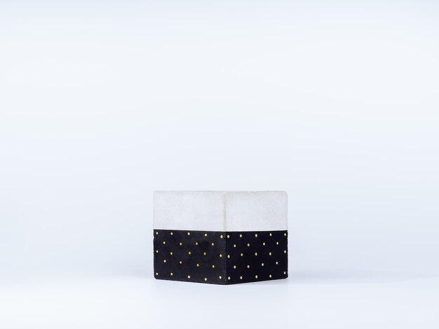 Empty DIY painted concrete planter isolated on white background with copy space. The cubic shape of the modern cement plant pot is painted with white dots on black.