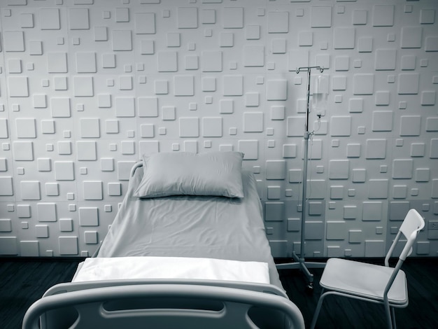회색 베개와 침대 시트 식염수 가방 의자 소파가 있는 병실에 있는 빈 전기 조절식 환자 침대 회복실의 창 근처에 있는 소파 의료 의료 및 보험 개념