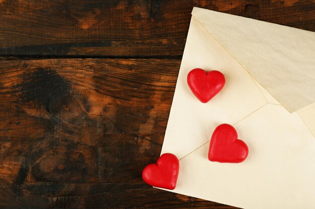 Empty envelope with hearts on rustic wooden table background