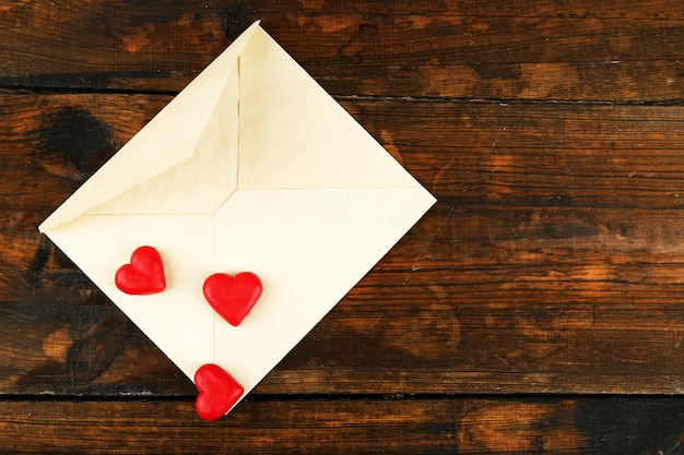 Empty envelope with hearts on rustic wooden table background