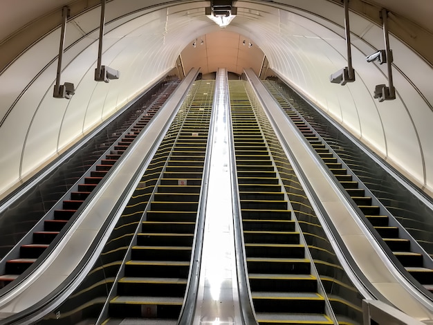 An empty escalator in metro. Transportation of people up and down stairs. Four escalators without people. Mall, elevate