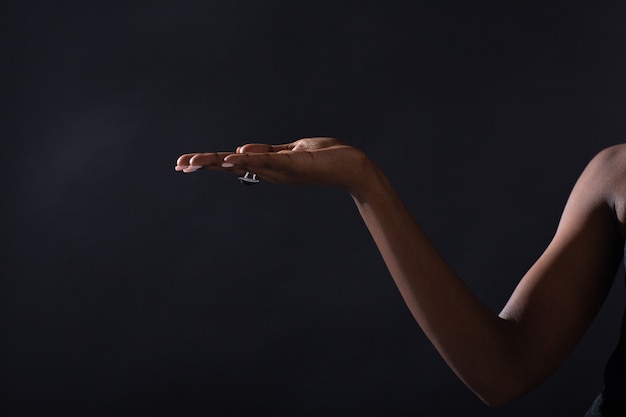 Photo empty female hand of african american woman holding and pointing on black background