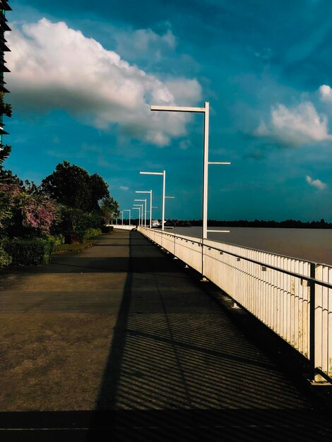 Photo empty footpath by sea against sky