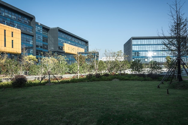 Empty footpath with modern office building exterior and blue cloudy sky during sunrise