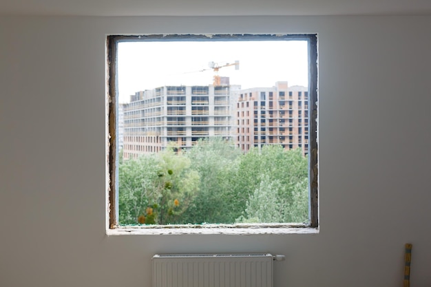 Empty frame on a wide panoramic window. gorgeous view from the\
window of an apartment in a multi-storey building. roofs of houses\
and trees from a height. beautiful view through the window. frame\
for