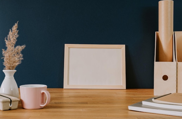 Empty frame on wooden desk and blue wall