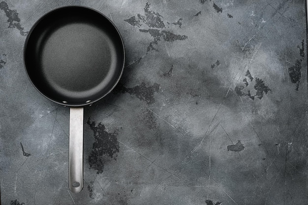 Empty frying pan set with copy space for text or food with copy space for text or food, top view flat lay, on gray stone table background