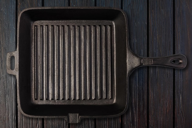 Empty frying pan on wooden background