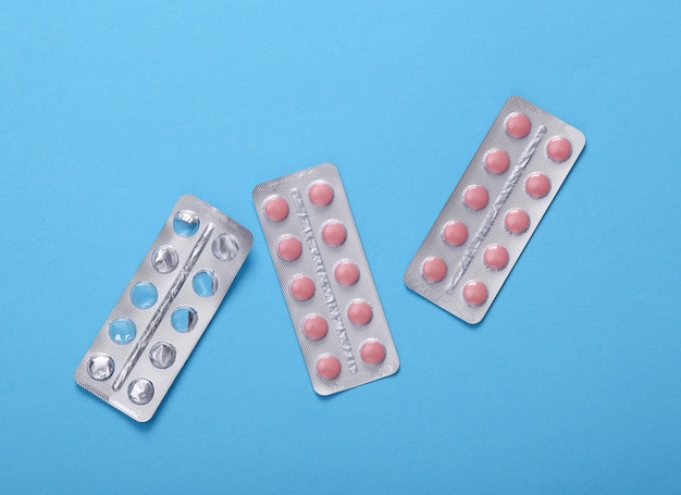 empty and full blister of pills on blue background top view