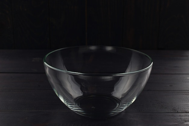 Пустая стеклянная миска на темном фоне