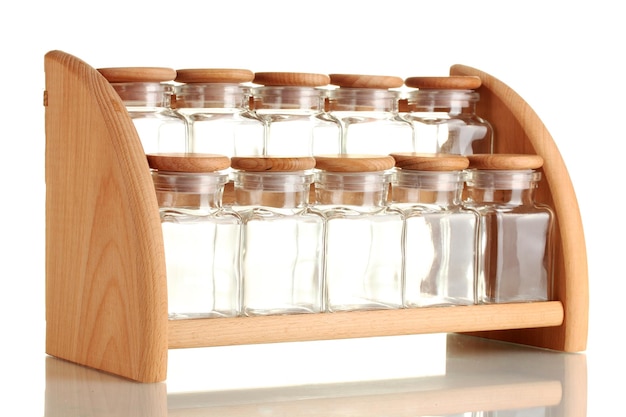 Empty glass jars for spices on wooden shelf isolated on white