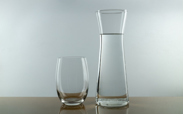 Empty glass and pitcher of water