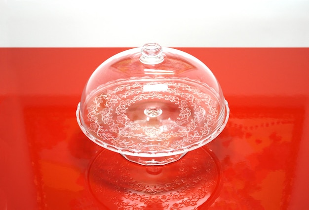 Empty glass vase on a red table