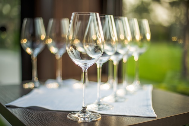 Empty glasses on exterior table, green grass.