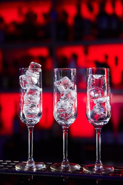 Пустые стаканы с кубиками льда на барной стойке