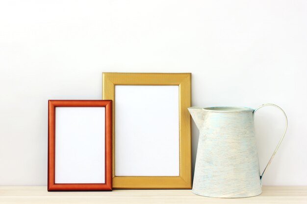 Empty gold photo frames and pitcher. 