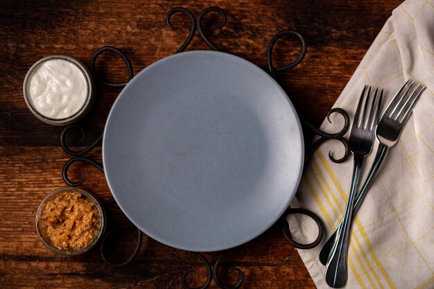 Empty gray plate and ketchup with mayonnaise forks nearby Preparing for serving