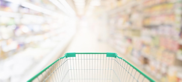 Empty green shopping cart in supermarket aisle