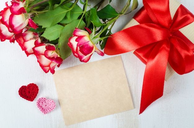 Empty greeting card, red roses and gift box