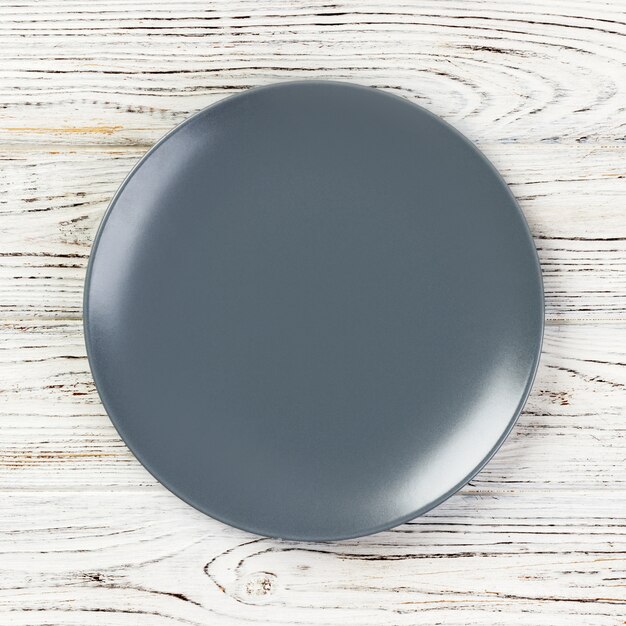 Empty grey plate on wooden background