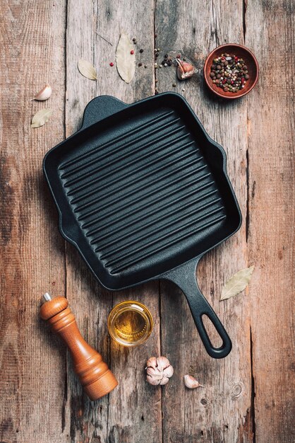 Empty grill iron pan and kitchen utensils on wooden background Top view Copy space Healthy clean food and eating concept Zero waste Cooking frame