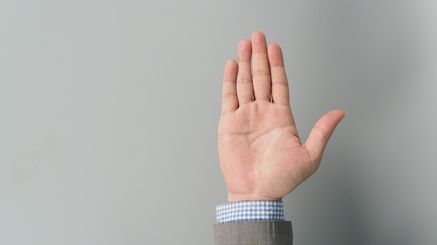 Empty hand palm in businessman grey suit on grey background.