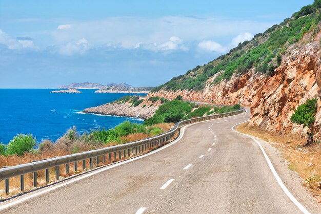 Foto autostrada vuota in montagna su uno sfondo blu del mare e del cielo