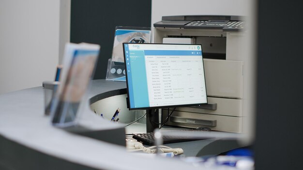 Empty hospital reception desk with computer and medical forms\
to make healthcare appointments and checkup visits. registration\
counter at health center facility lobby, consultation exam.