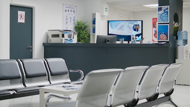 Photo empty hospital waiting room in lobby with reception counter at medical facility, used to help patients with appointments and healthcare insurance. medical waiting area with front desk.