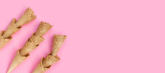 Empty ice cream cone on pink background