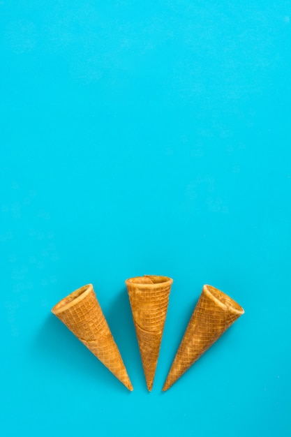 Empty ice cream cornets on blue table