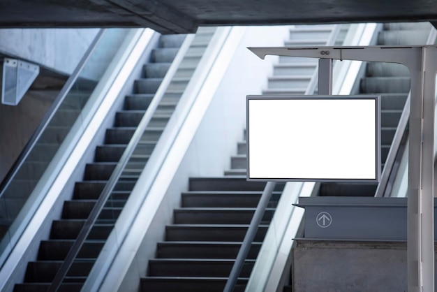 Empty information board at the train station with escalators in the background