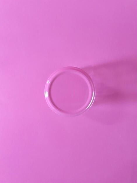 ピンクの背景に分離されたピンクのキャップと空の瓶