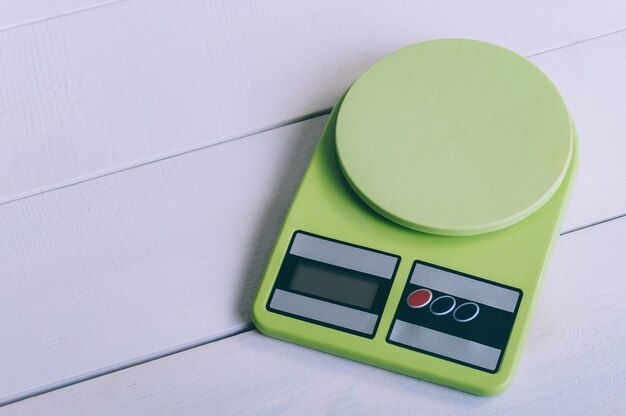 Empty kitchen scales on a wooden table.