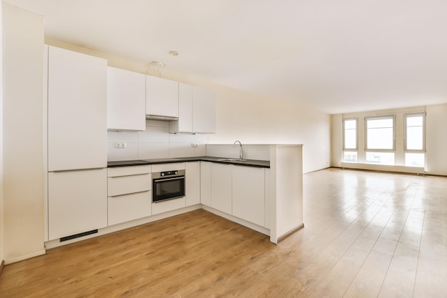 Premium Photo | An empty kitchen with white cabinets and black counter ...