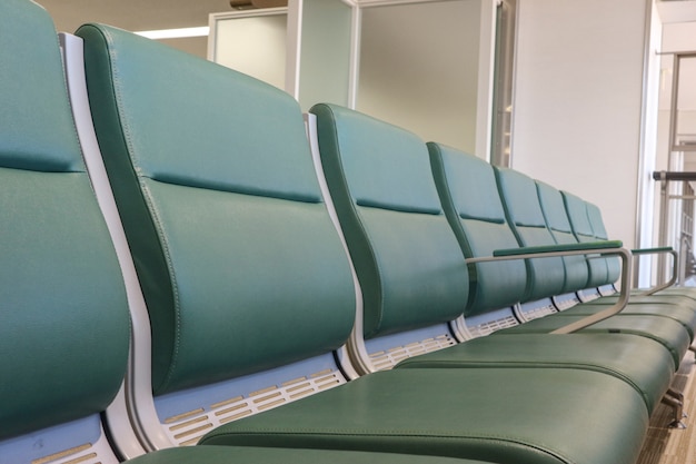 Пустое кожаное сиденье для ожидания посадки в зоне аэропорта.