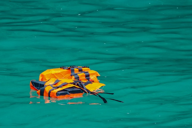 Foto giubbotto di salvataggio vuoto che galleggia sull'acqua di mare. perso il concetto umano o minaccioso.