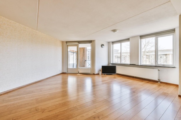 Photo an empty living room with wood floors and windows