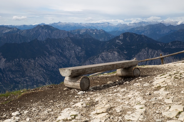 Empty lonely wooden bench on top of the alpine mountains.