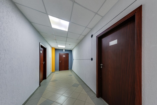 empty long corridor with doors for room office in interior of modern apartments office or clinic