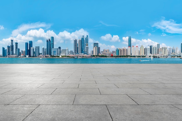 The empty marble floors and the skyline of Qingdao's urban buildings.